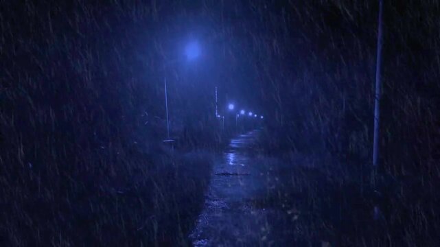 Dark alley path during a midnight storm with glowing streetlights and pouring rain.
