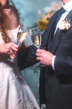 View of a bride and groom clinking champagne glasses during a wedding celebration with elegant attire and floral details Rio de Janeiro, State of Rio de Janeiro, Brazil.