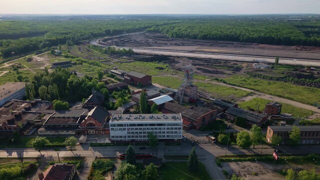 Aerial drone parallax view of the historical Makoszowy coal mine complex in Poland. Historic industrial buildings and steel headframe.