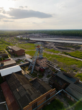 Vertical aerial drone photograph of the historical Makoszowy coal mine complex in Poland. Historic industrial brick buildings and steel headframe.