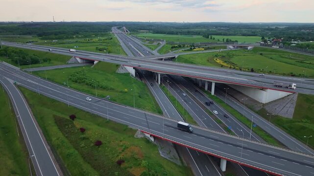 Aerial drone view flying backward over a massive highway interchange in Poland. Complex freeway junction network connecting A1 and A4 motorways.