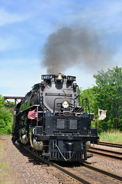 The massive Union Pacific Railroad 'Big Boy' steam engine rounding a curve while steaming under bridges and through a west suburban Chicago community during its 250th Anniversary tour.