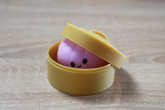 Pink Anti-Stress Squash squishy Dumpling Lying In Yellow Case