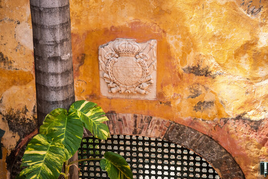 Coat of arms on an orange wall in the Palace of the Inquisition in the Old Town, Cartagena, Colombia