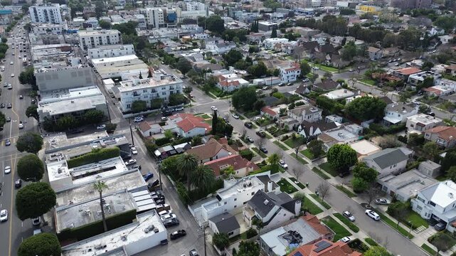 Shops along S Robertson Blvd sit beside clustered homes stretching toward Airdrome St. Flat roofs, bright facades, and scattered tree canopies contrast with parked vehicles in Los Angeles, CA