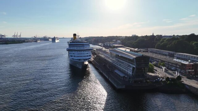 Hamburg, Germany - 01 June 2026: Aerial view of Hamburg Cruise Center Altona with a large cruise ship docked at the terminal along the Elbe river under a clear sky.