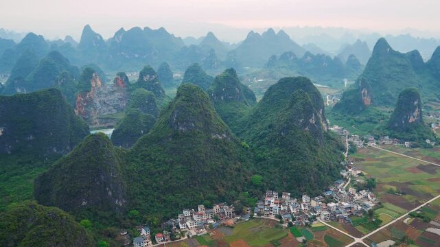 Spectacular aerial view of famous guilin karst mountains landscape in southern china. Flying over lush green hills, villages and rice paddies of the li river valley near yangshuo