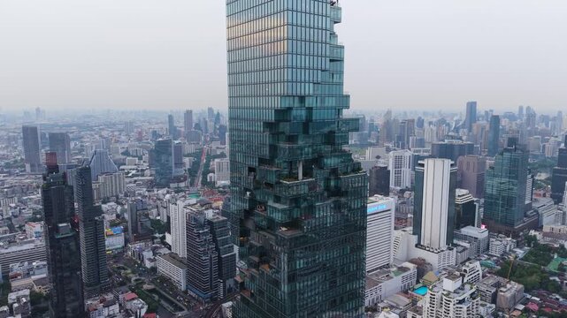 Bangkok, Thailand - 31 May 2026: Aerial view of King Power Mahanakhon skyscraper with its unique pixelated facade overlooking the urban skyline under a hazy sky.
