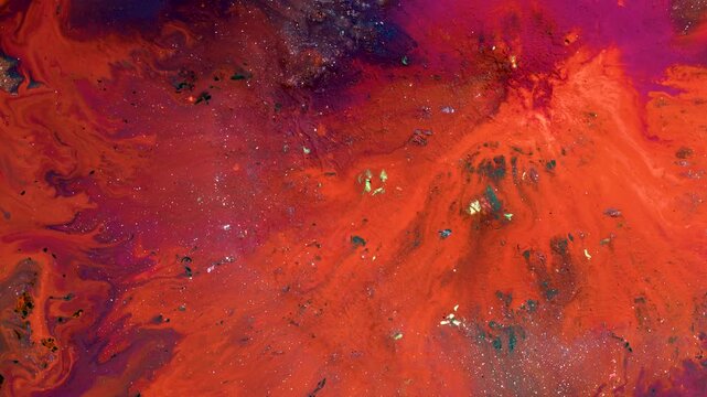 Vibrant abstract fluid art swirls in fiery reds and purples. Colors blend like molten lava or cosmic nebulae.