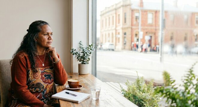 middle-aged woman sitting at a window in a cafe, with copy space