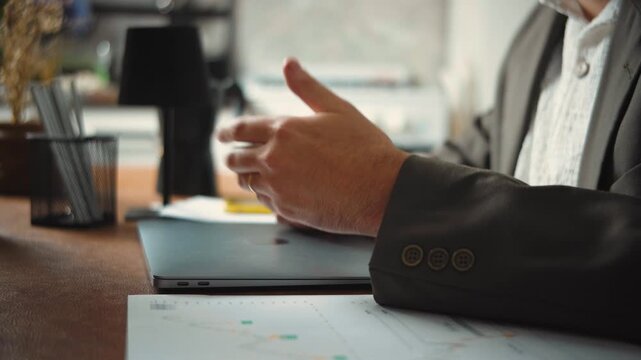 Businessman in a formal suit leading a financial advisory meeting and presenting financial analysis charts to a company team. Business management concept.
