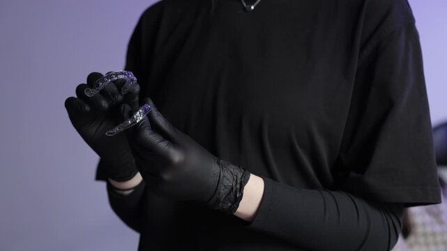 Dentist holding invisible transparent aligners for teeth correction