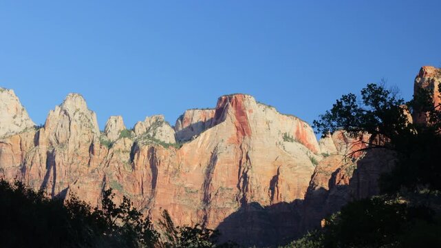 Dawn light on the rocky bluffs and windblown trees of Zion National Park in southern Utah