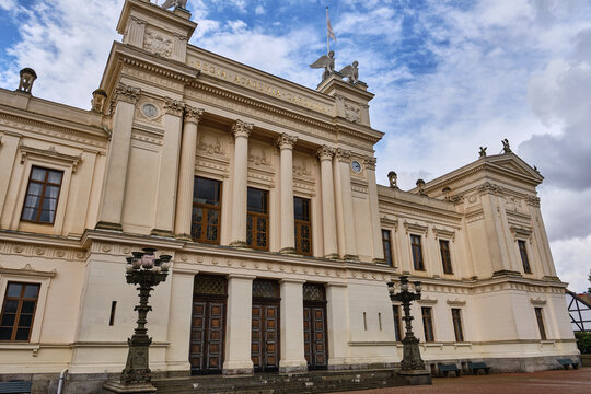 Lund, Sweden - 02 August 2025: View of the neoclassical main building of Lund University with its grand columns and sphinx statues under a cloudy sky.