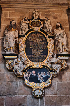 Lund, Sweden - 02 August 2025: View of an ornate epitaph monument with Latin inscriptions and religious sculptures inside the historic Lund Cathedral.