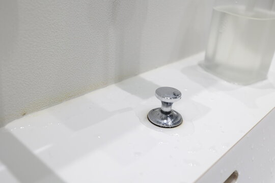 洗面所の角部分。壁クロスの黄ばんだ汚れと白いシンク