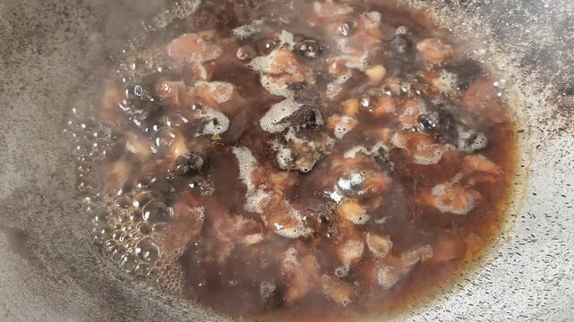 Cooking tamarind sauce in pan, indoor Chiangmai Thailand.