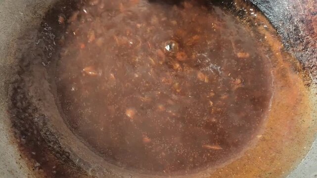 Cooking tamarind sauce in pan, indoor Chiangmai Thailand.
