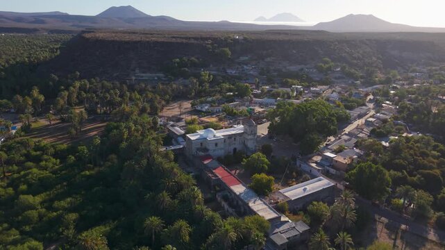 View aerial shots of the Mission Church located in San Ignacio, Baja California Mexico with its surroundings in the oasis town area.