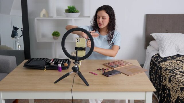 Young female influencer recording a makeup tutorial video