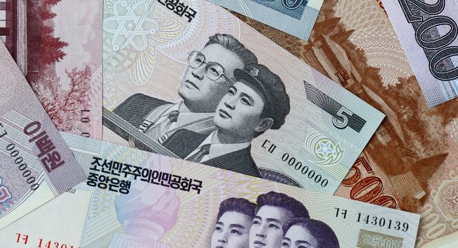 North Korean won money bills in pile on table. North Korea KPW currency cash close up