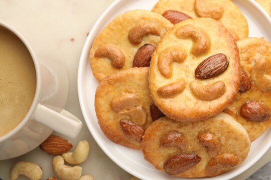Yummy nut cookies served with coffee on table, flat kay