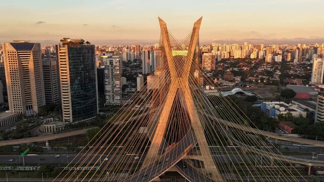 Time-lapse video with aerial sunset view of Oct&aacute;vio Frias de Oliveira Bridge, the cable-stayed bridge over Marginal Pinheiros in S&atilde;o Paulo, with vehicle traffic - S&atilde;o Paulo, Brazil