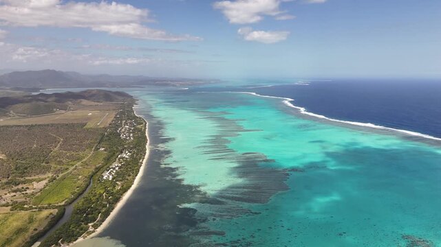 Aerial turquoise lagoon coastline in New Caledonia showcasing coral reef patches, shallow turquoise waters, the longest barrier reef in the world New Caledonia.