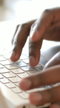 Vertical video: Typing hands with fingers landing, tapping white laptop keyboard for work at desk
