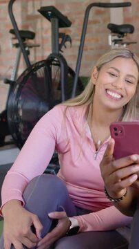 Vertical video: Reacting to pink phone appearing woman in zip-up top viewing shared phone by bikes
