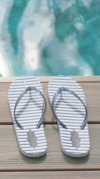 Vertical video: Shifting sunlight animating pool glints behind centered striped flip-flops on deck
