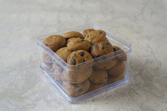 Freshly baked chocolate cookies stored neatly in a transparent plastic box