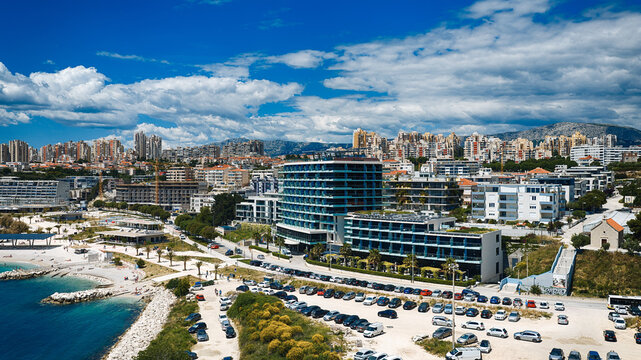 Aerial view of the modern Radisson Blu Resort and Spa building with blue glass balconies overlooking the Adriatic coast and city skyline in Split, Split-Dalmatia County, Croatia.