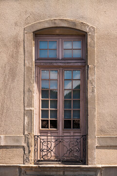 Ancient stone wall frames a vintage wooden window, Carcassonne