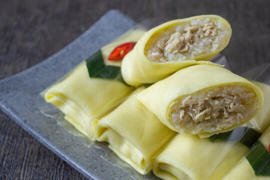 Traditional Javanese semar mendem, savory chicken stuffed sticky rice wrapped in thin egg omelet, Authentic Indonesian snack