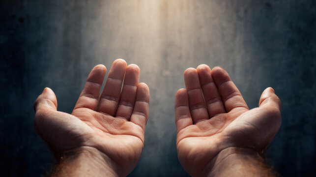 Open hands prayer gesture human hand palms up lifted hand open palm light beam dark background close up