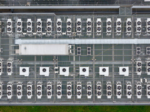 Aerial view of rows of industrial air conditioning units and ventilation fans on the roof of the Datacenter T-Mobile in Warsaw, Mazowieckie, Poland.