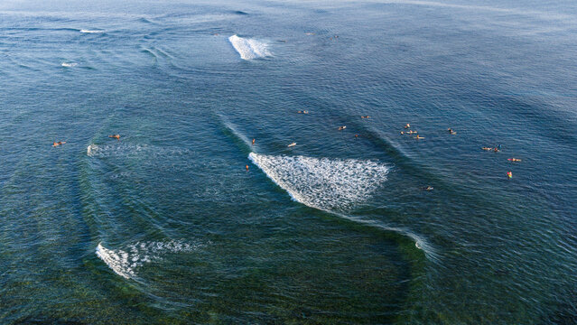 Aerial view of surfers waiting for waves in the blue ocean at Cloud 9 Surfing Area in General Luna, Caraga, Philippines.