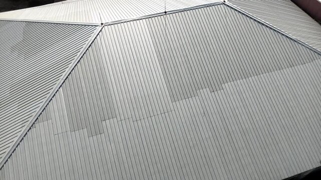 A view from above of corrugated metal roofing panels featuring geometric lines and industrial architecture.