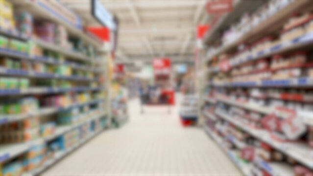 Blurred View of a Brightly Lit Supermarket Aisle with Shelves