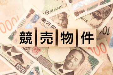 Fototapeta premium 「競売物件」と書かれたブロックとたくさんの一万円札