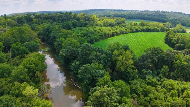 Aerial view of a serpent mound surrounded by lush greenery and rivers.