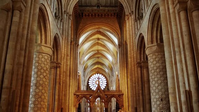Majestic Durham Cathedral interior featuring soaring stone arches, vaulted Gothic ceiling, and illuminated rose window above historic nave