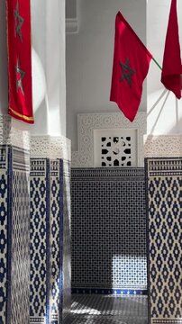 Vertical social media video featuring Moroccan flags above intricate blue zellij tilework within historic Dar el-Makhzen palace courtyard in Fez