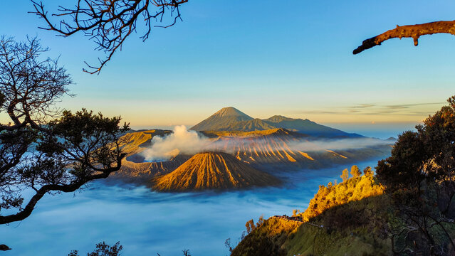 Panoramic sunrise view of Mount Bromo, Mount Batok, and surrounding volcanic landscape in East Java, Indonesia