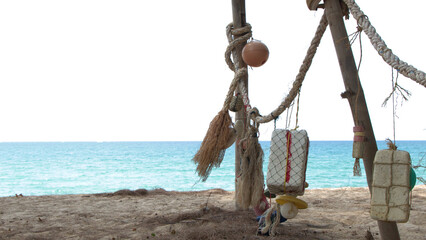 Weathered Fishing Floats and Ropes Hanging on a Tropical Phuket Beach © blueringmedia