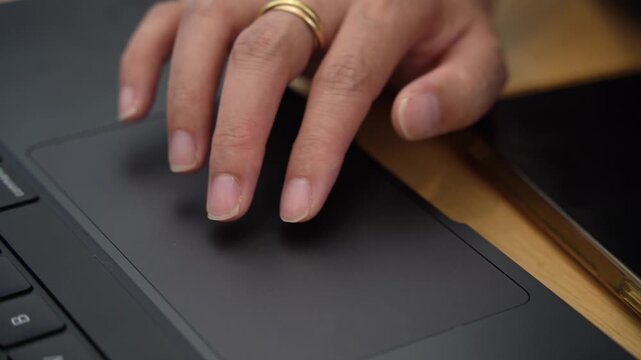Asian female hand using a laptop touch pad searching for knowledge and information.
