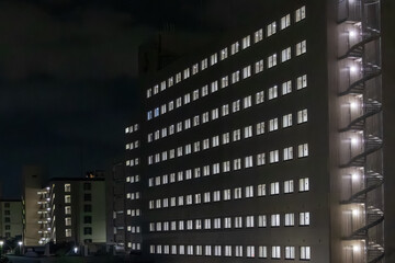 Fototapeta premium Residential building with illuminated windows at night