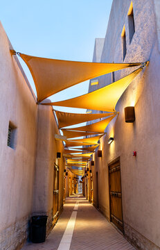 A narrow heritage street with traditional Najdi architecture and sun shades in the Al Gadimah historic district of Riyadh, Saudi Arabia.