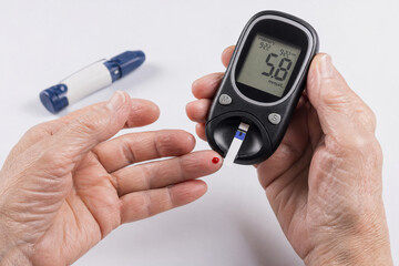 Fototapeta premium Diabetic person checking blood sugar level with glucose meter